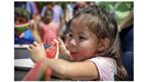 Small child enjoying watermelon in the watermelon eating contest